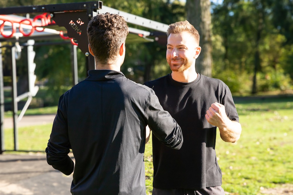 Coach guiding a client during calisthenics training
